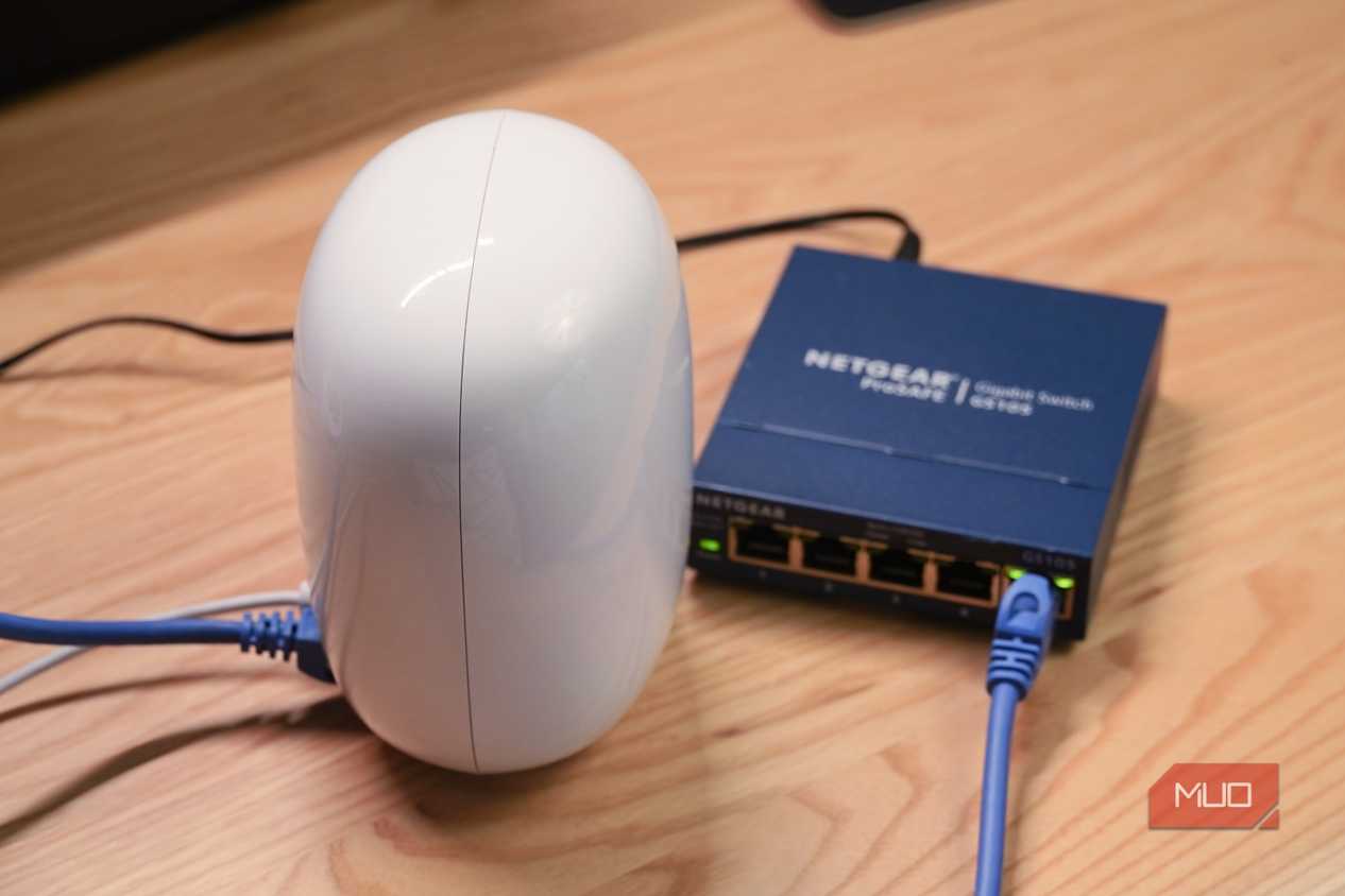An angled view of a Google Nest Wi-Fi Pro router connected to an unmanaged Ethernet switch.