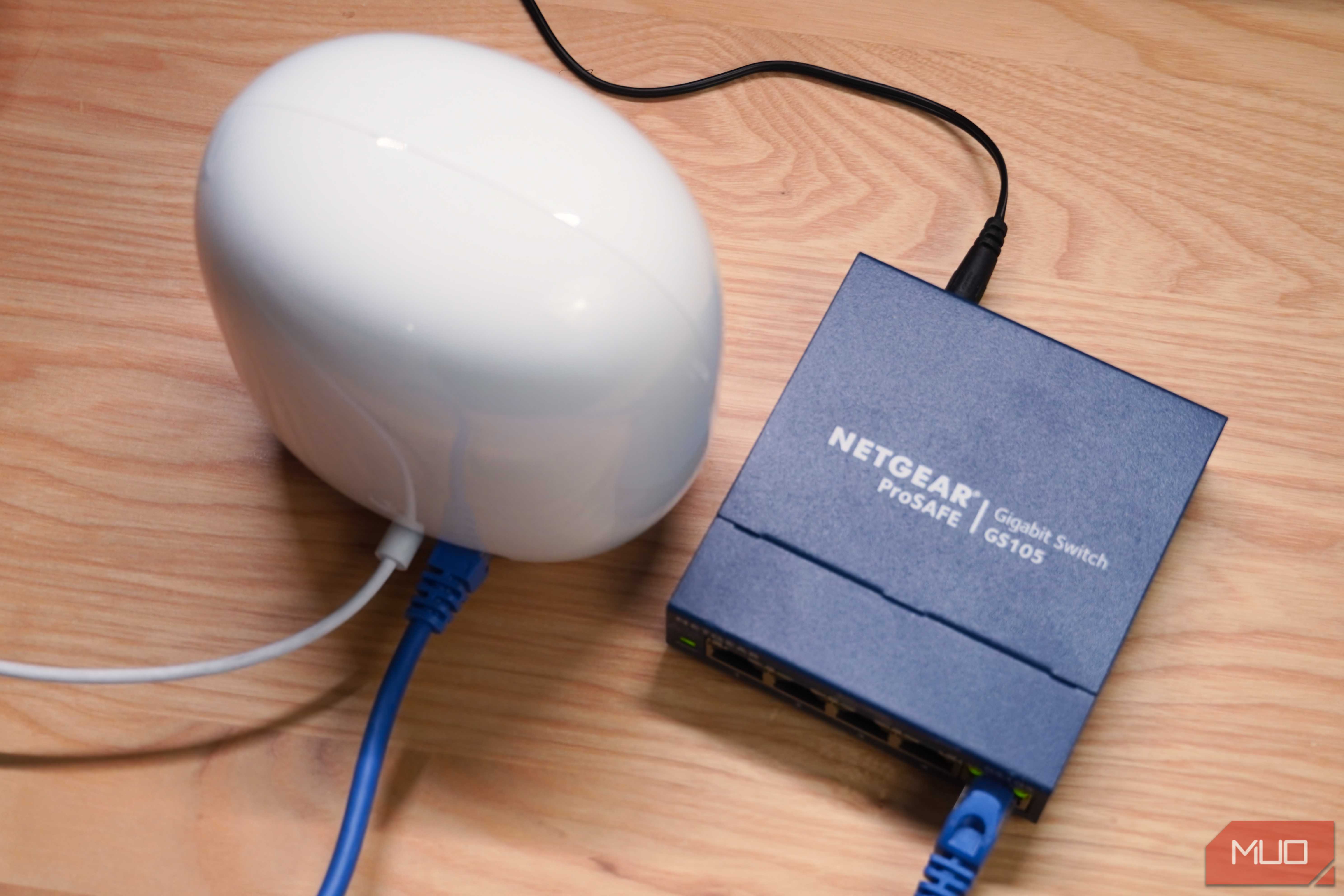 A top-down view of a Google Nest Wi-Fi Pro connected to an unmanaged networking switch.
