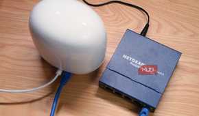 A top-down view of a Google Nest Wi-Fi Pro connected to an unmanaged networking switch.