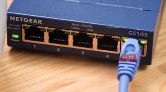A close-up of an Ethernet cable plugged into an unmanaged switch.