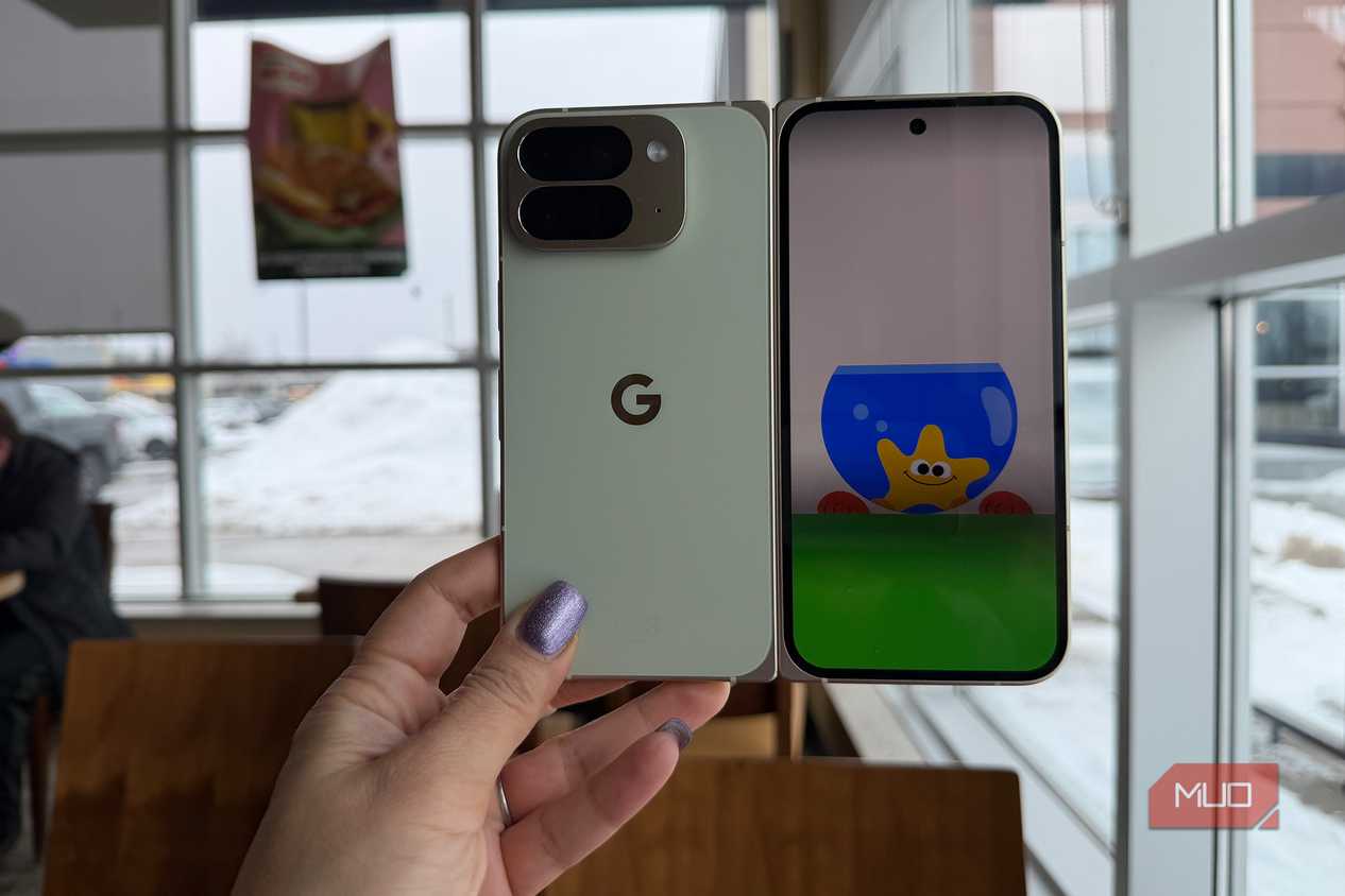 A hand holding a Google Pixel 10 Pro Fold phone with the Made You Look animation on the front.