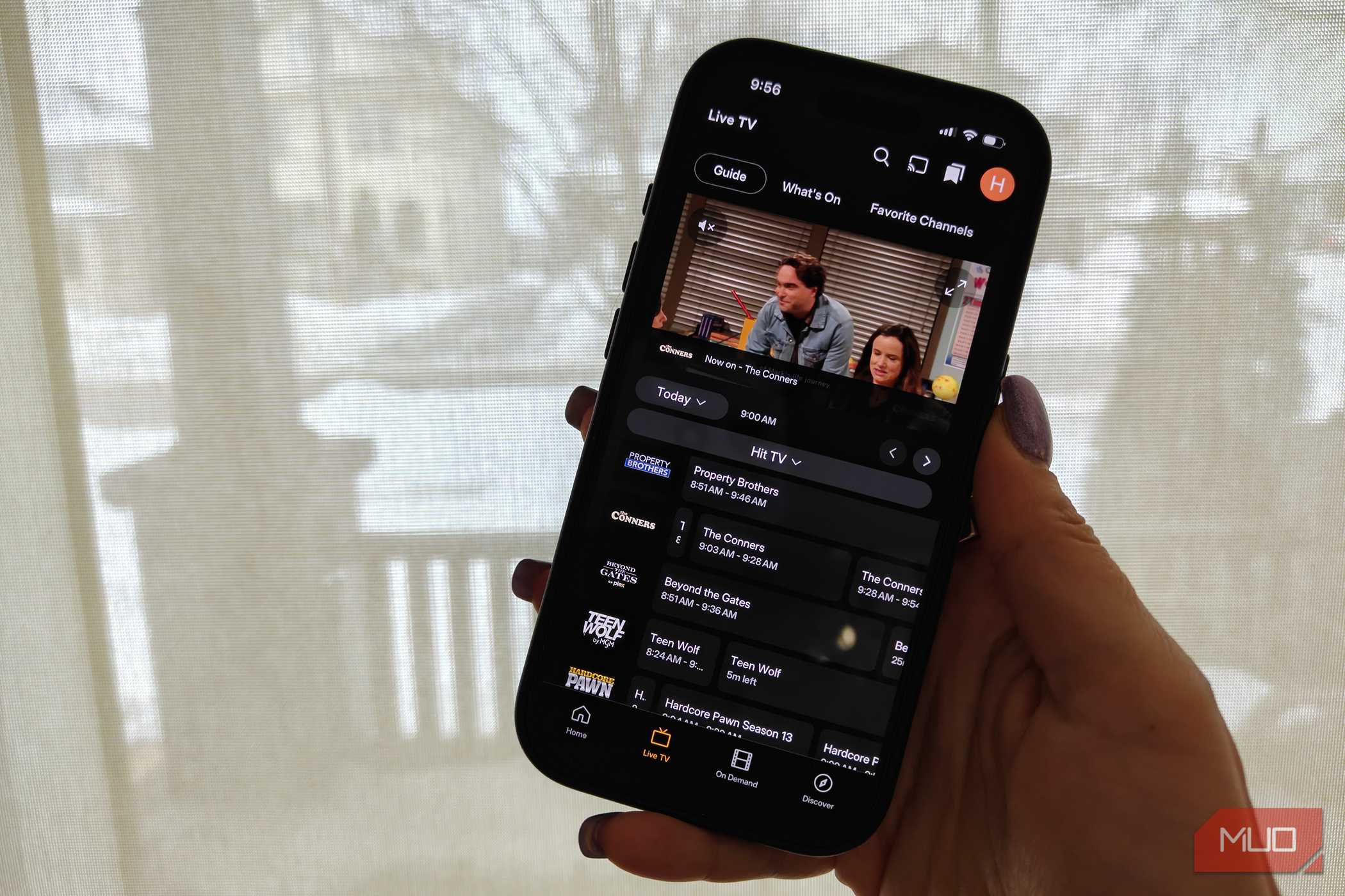 A phone showing the Plex live TV guide and The Conners playing in a small window.