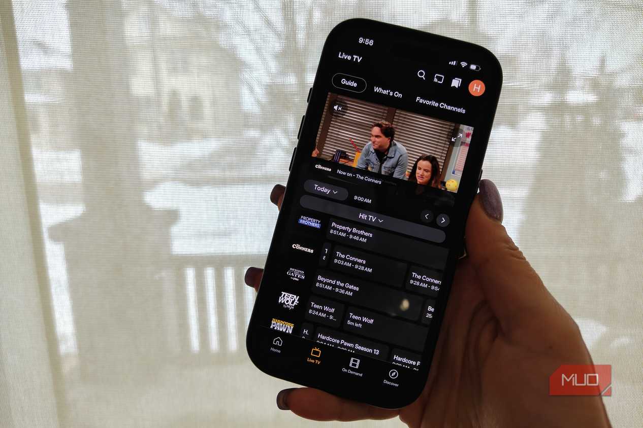 A phone showing the Plex live TV guide and The Conners playing in a small window.