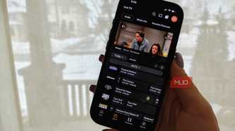 A phone showing the Plex live TV guide and The Conners playing in a small window.