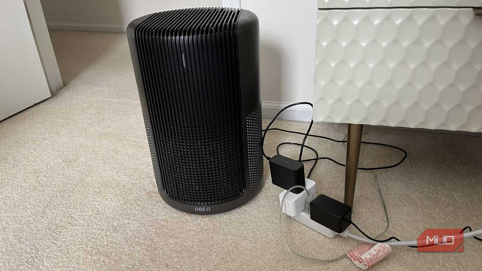 Un purificador de aire en el suelo conectado a un enchufe inteligente