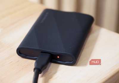 A Samsung T9 Portable SSD transferring data with the LED status light orange.