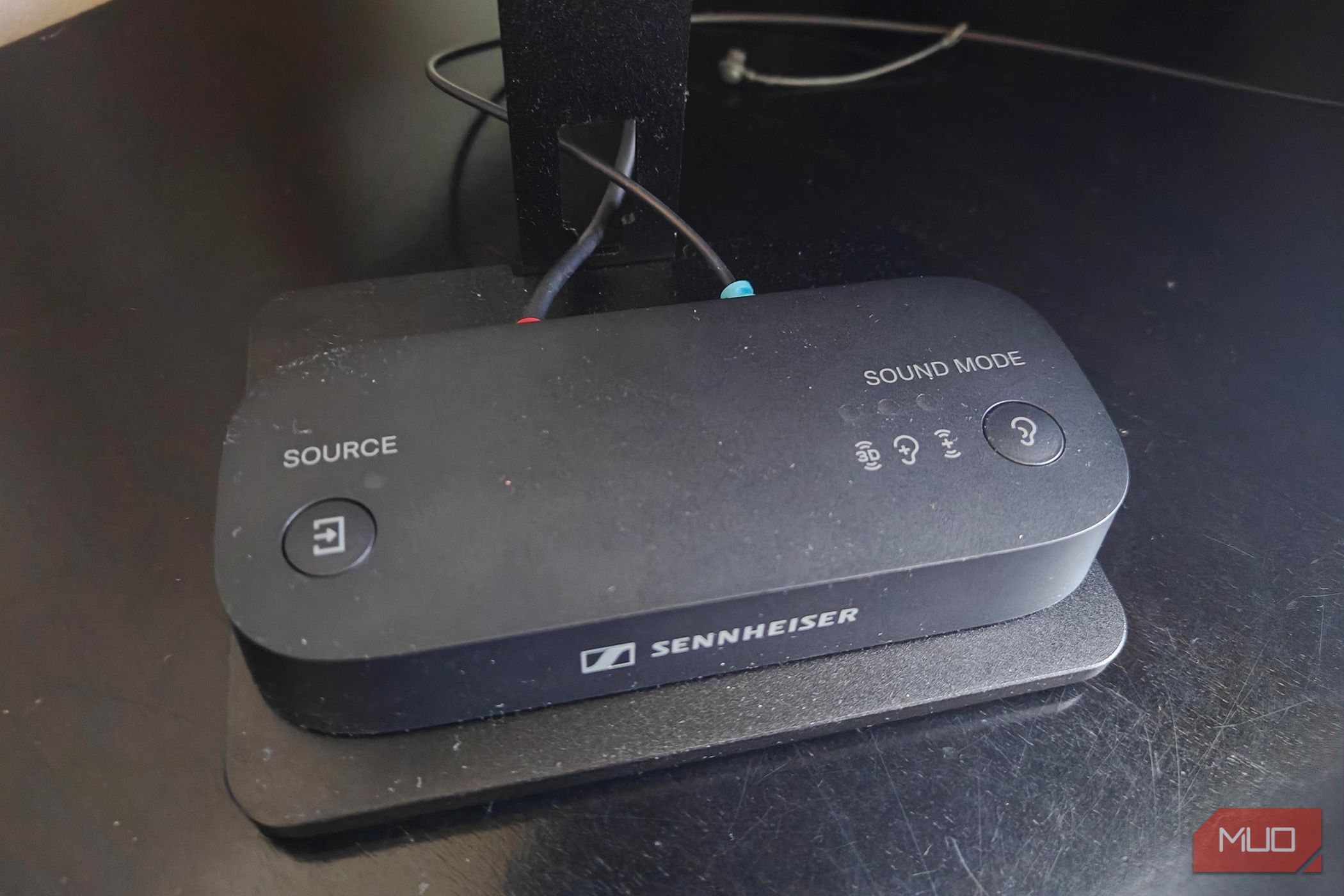 The Sennheiser BTA1 Bluetooth transmitter on a TV stand.