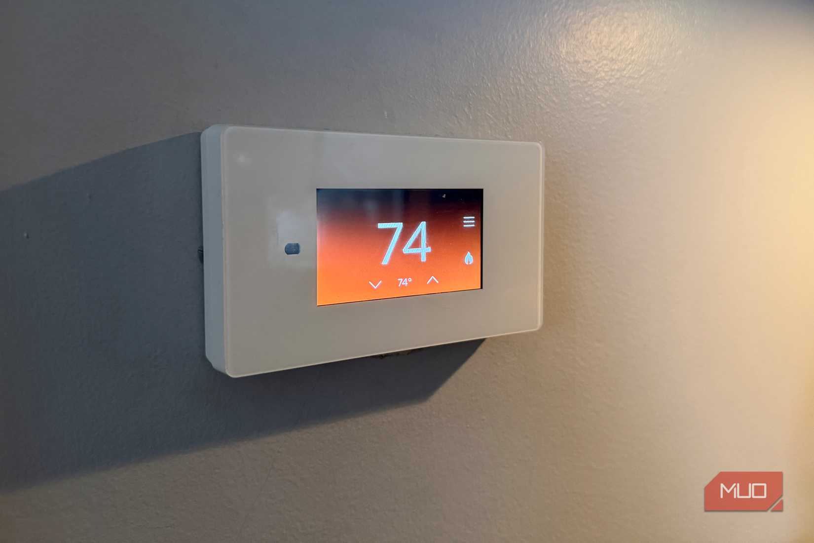 A smart thermostat on a wall showing heating.