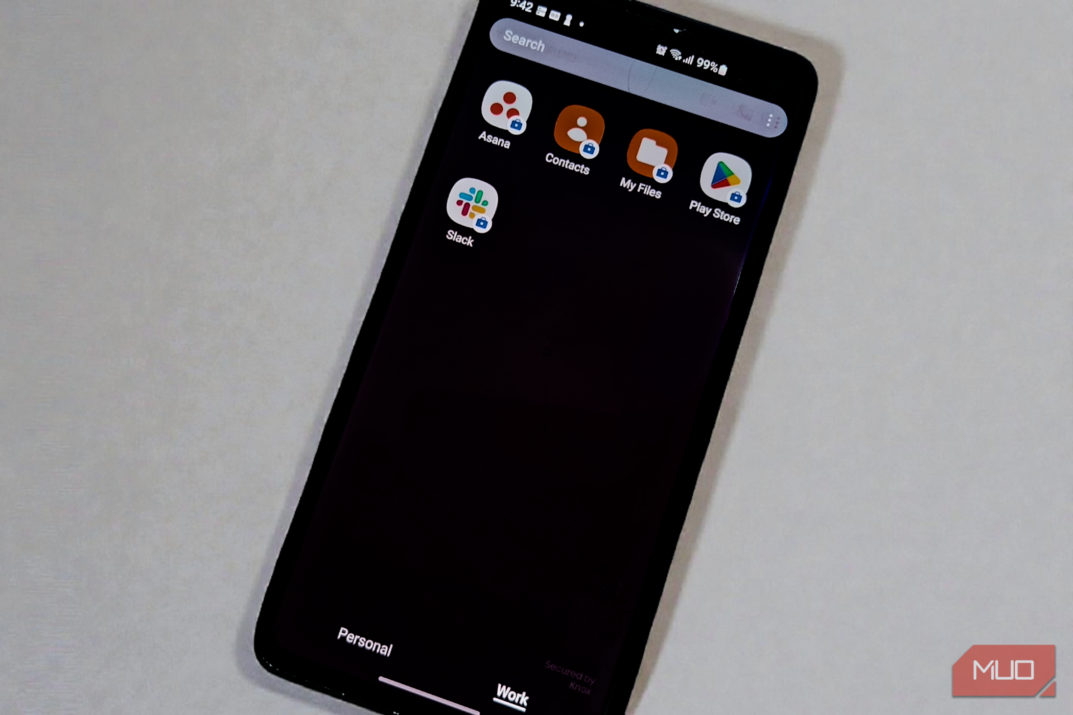 Smartphone showing isolated work profile apps, including Asana and Slack, with the Work tab selected.