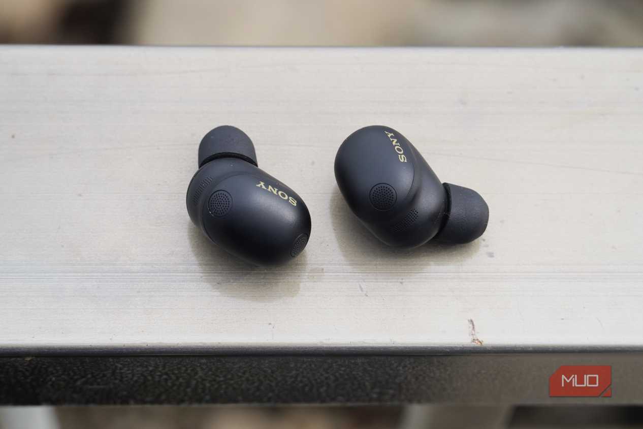 The Sony WF-1000XM6 earbuds on a railing.