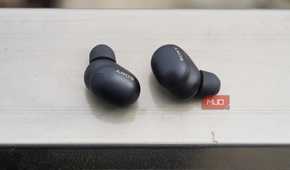 The Sony WF-1000XM6 earbuds on a railing.
