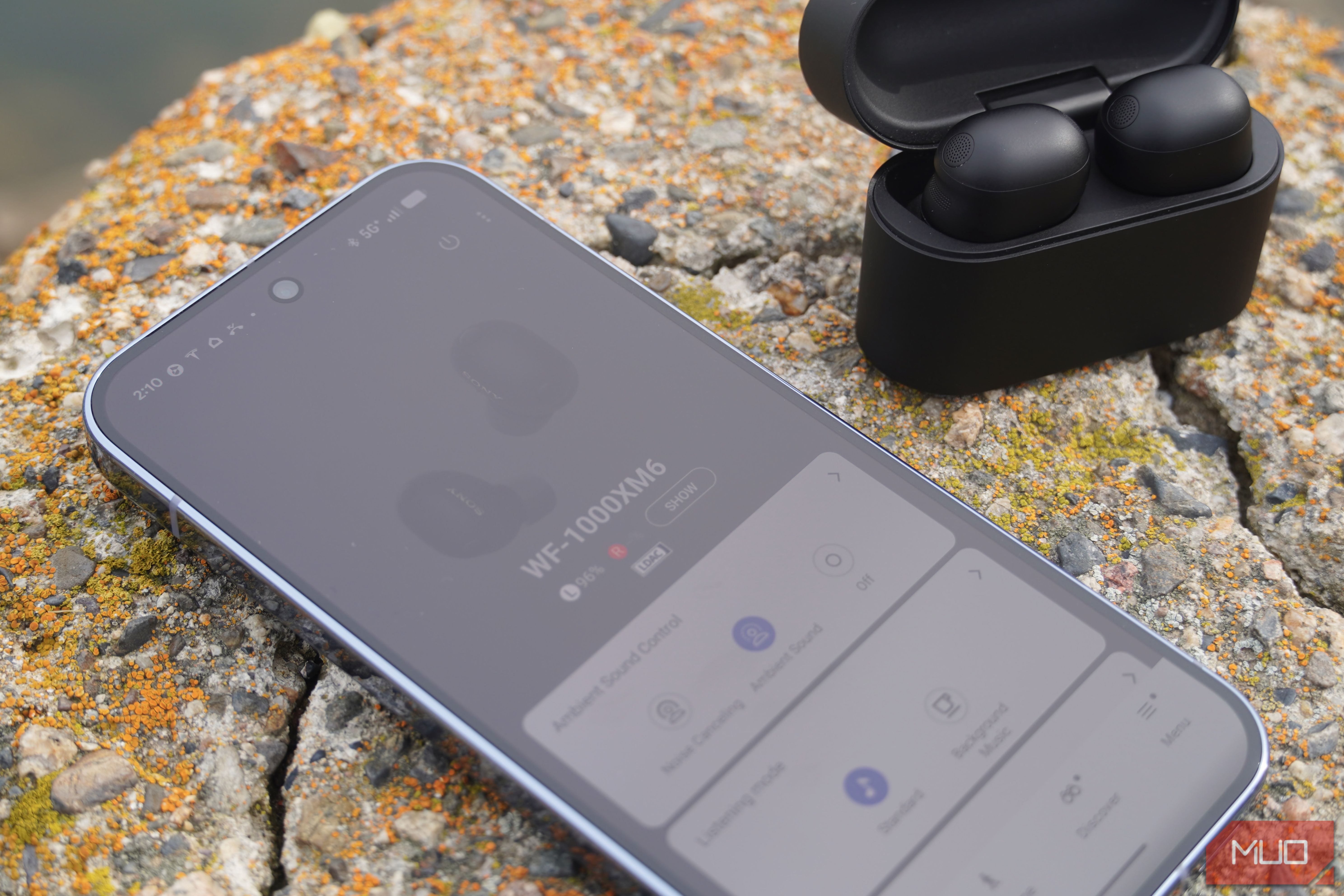 The Sony WF-1000XM6 app settings next to the earbuds.