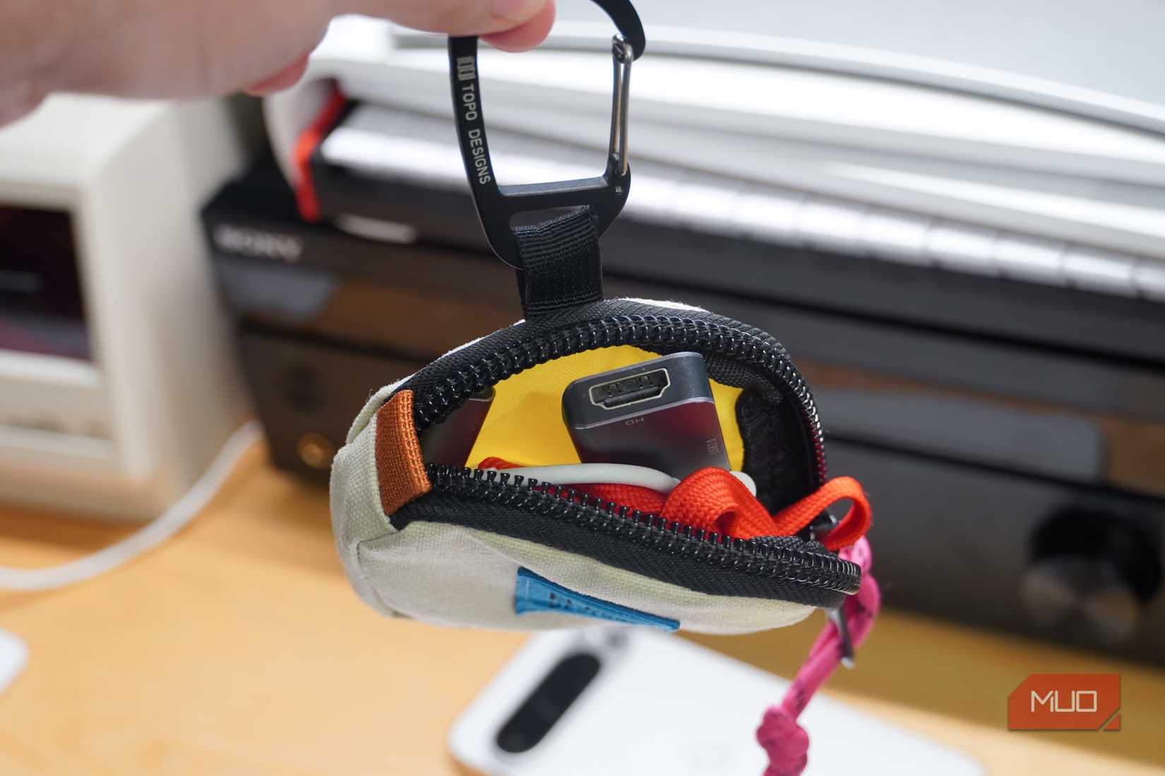 A collection of tech essentials stuffed into a Topo Designs Square Bag.