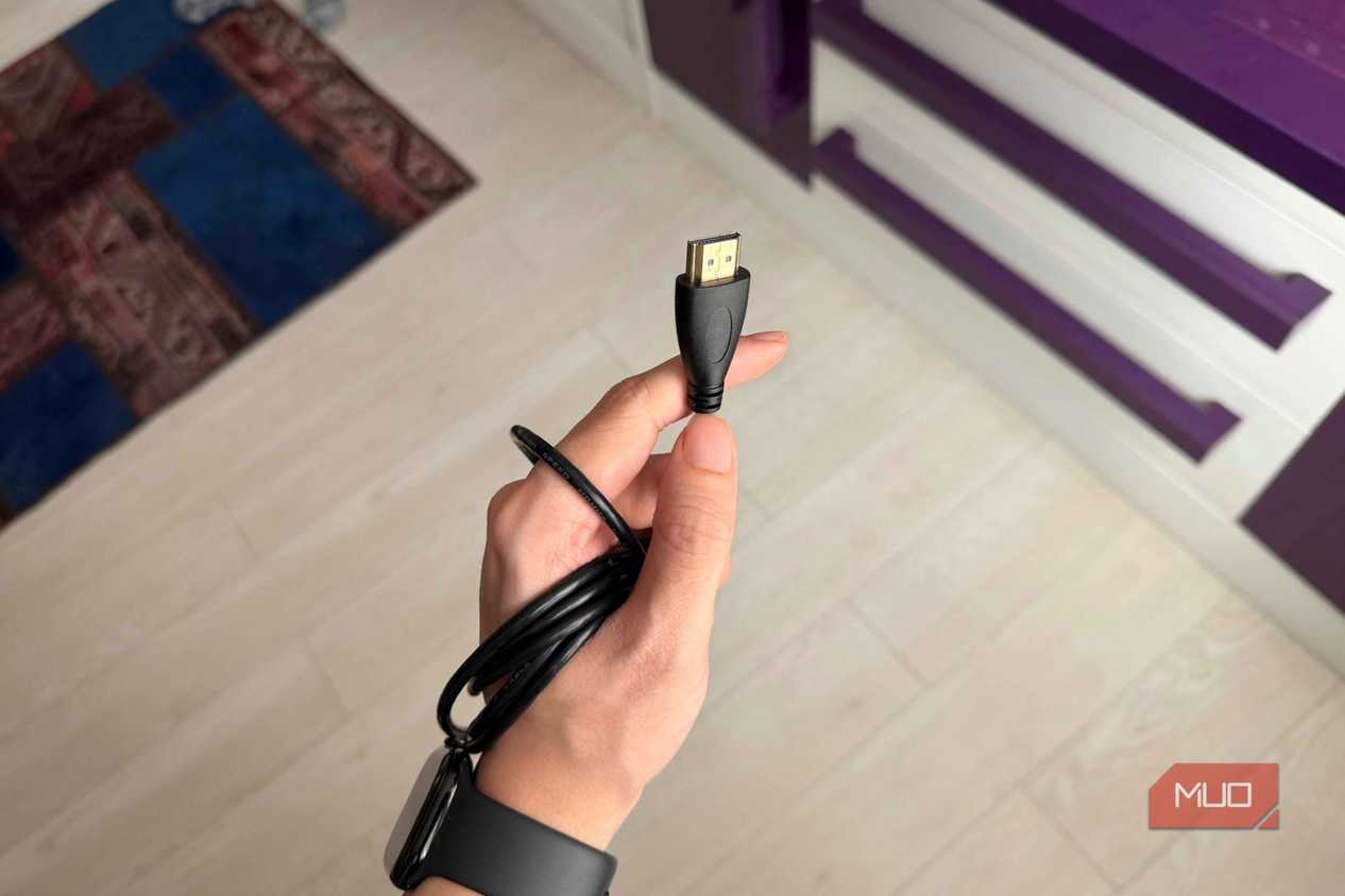 A hand holding an HDMI cable-1