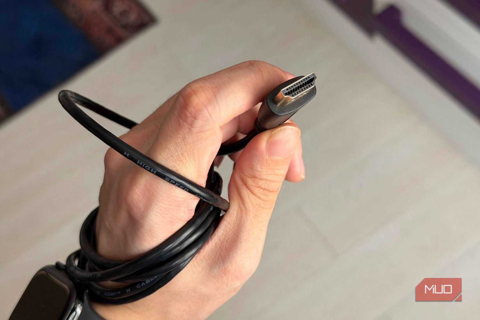 A hand holding an HDMI cable showing the pins