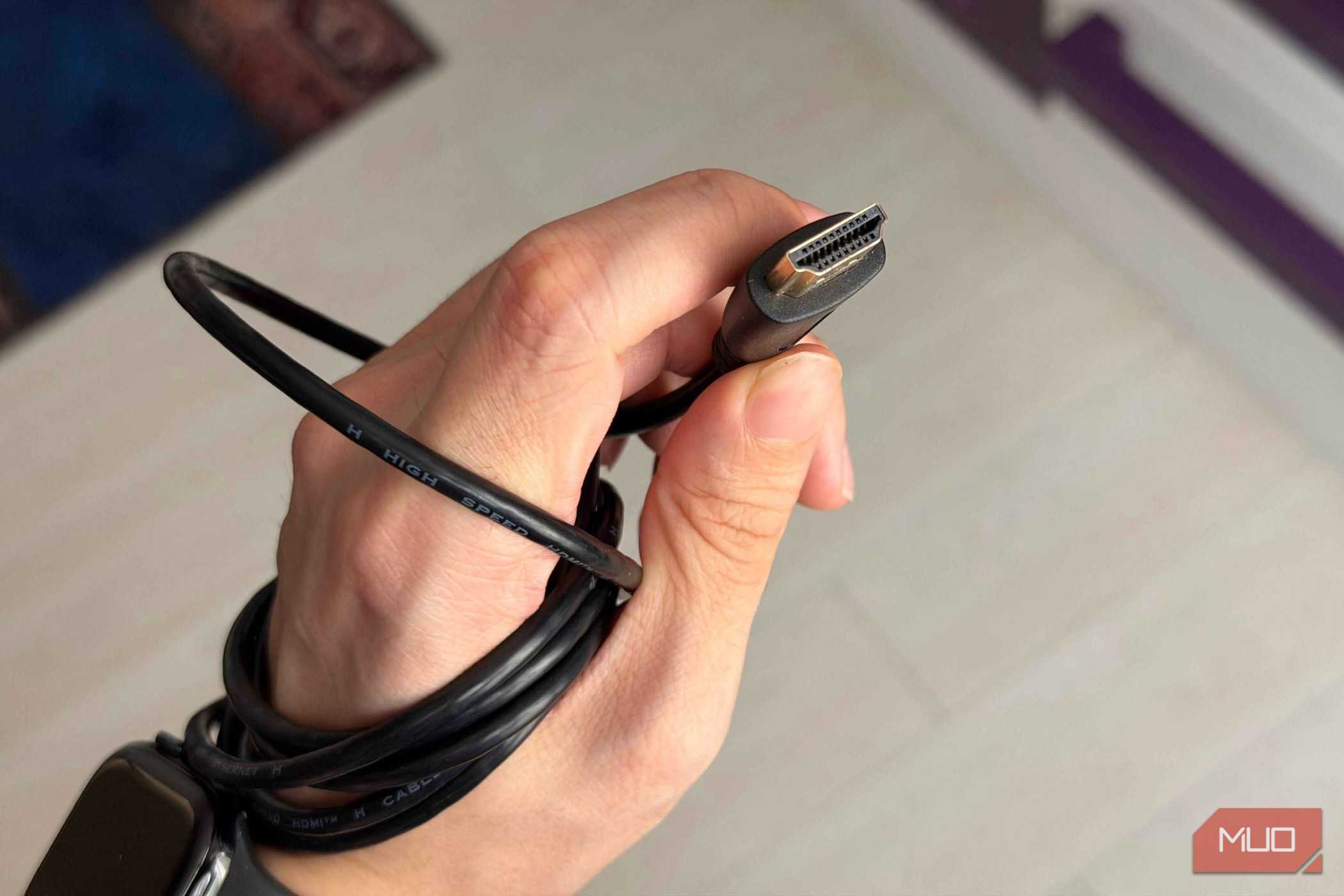A hand holding an HDMI cable showing the pins