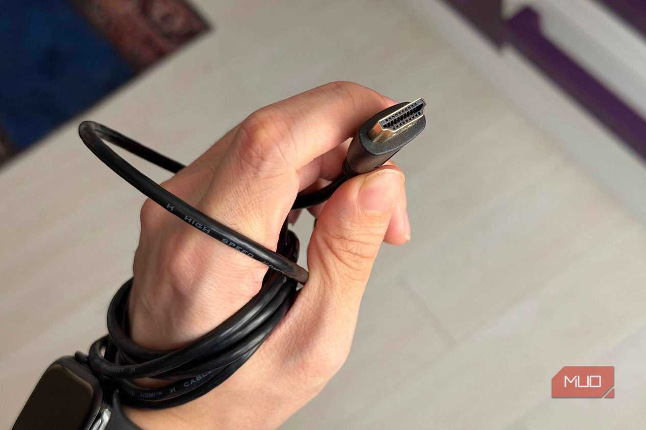 A hand holding an HDMI cable showing the pins