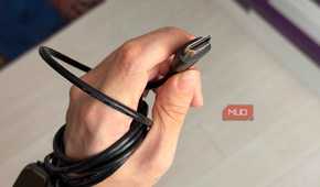 A hand holding an HDMI cable showing the pins