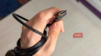 A hand holding an HDMI cable showing the pins