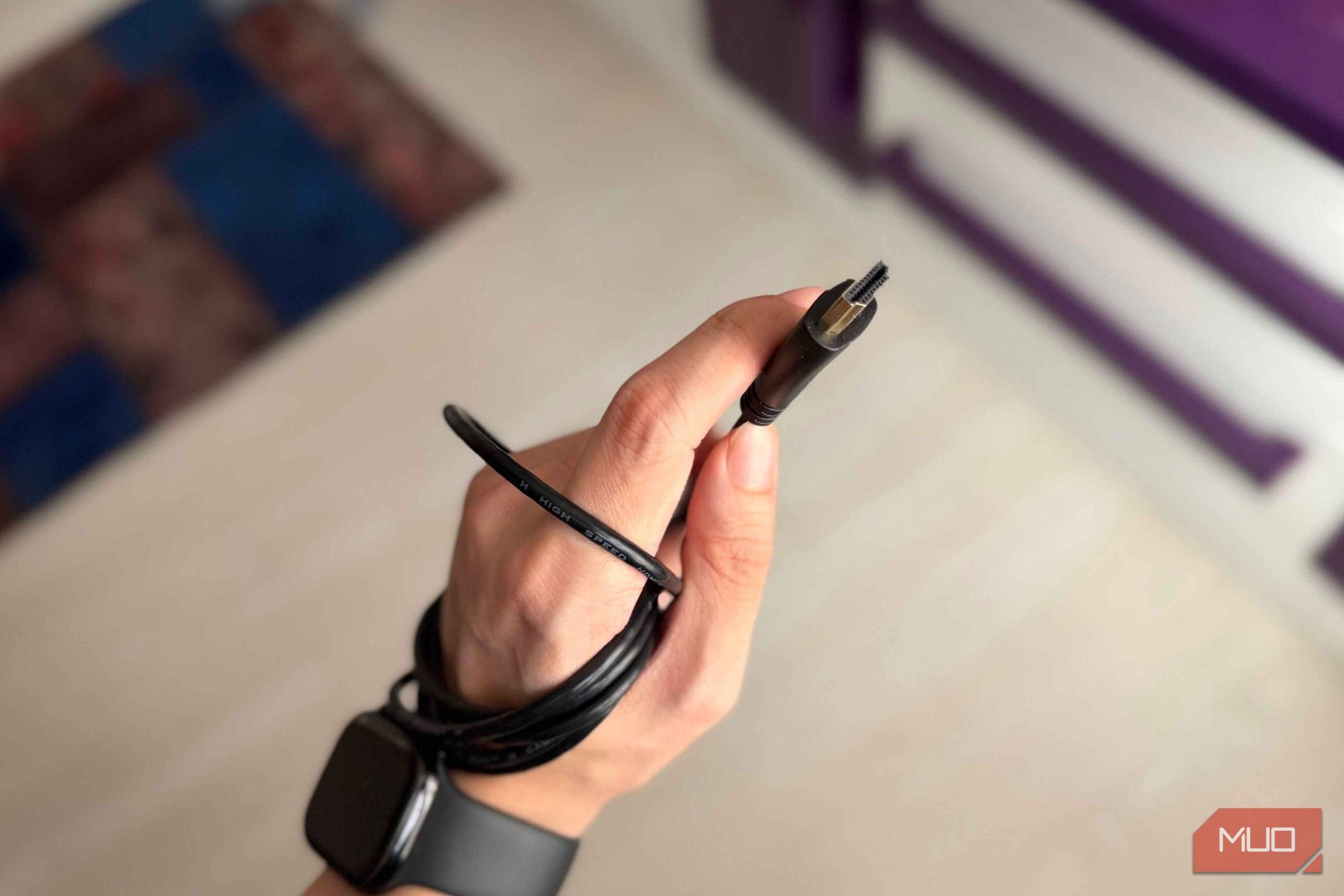 An HDMI cable and connector held in a hand