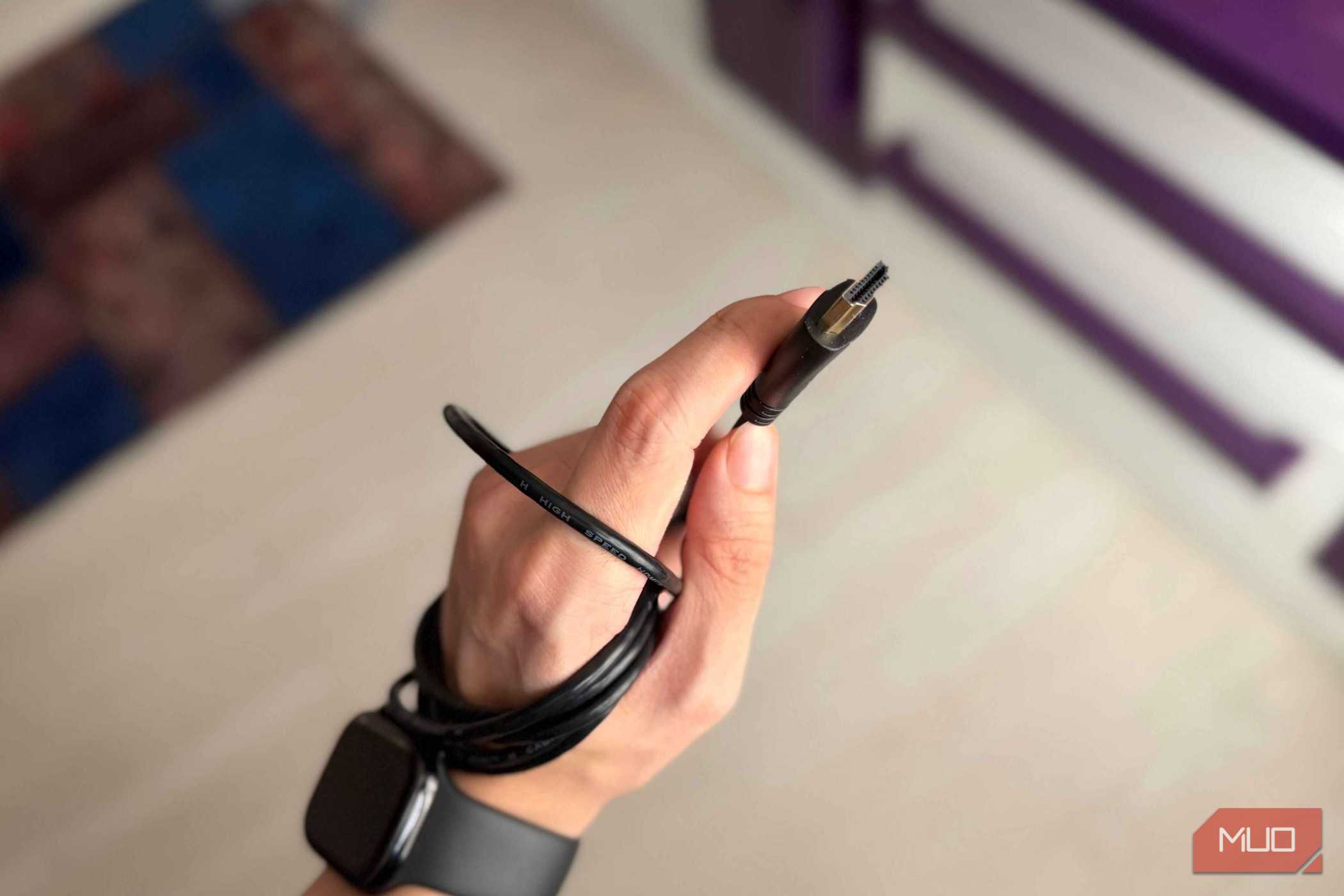 An HDMI cable and connector held in a hand