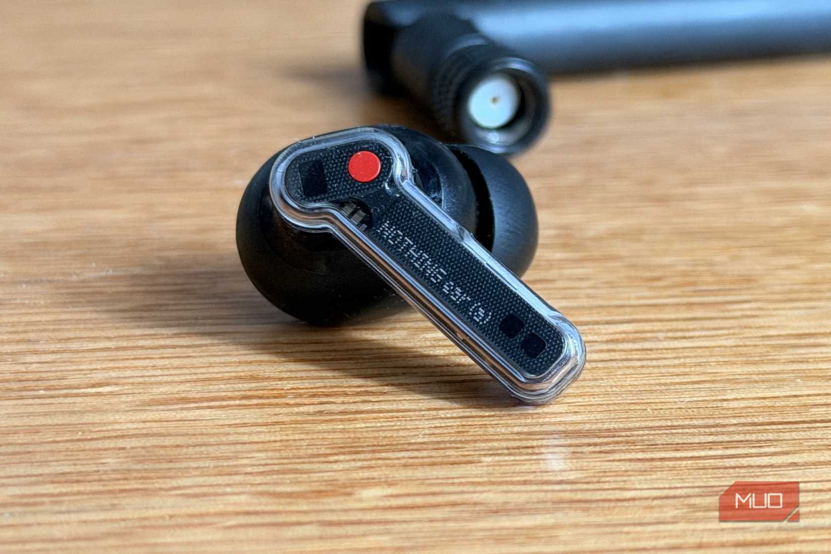 Nothing Ear 1 transparent earbud on wooden desk
