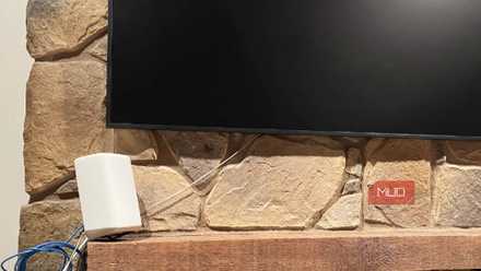 An Xfinity router under a TV on a mantle