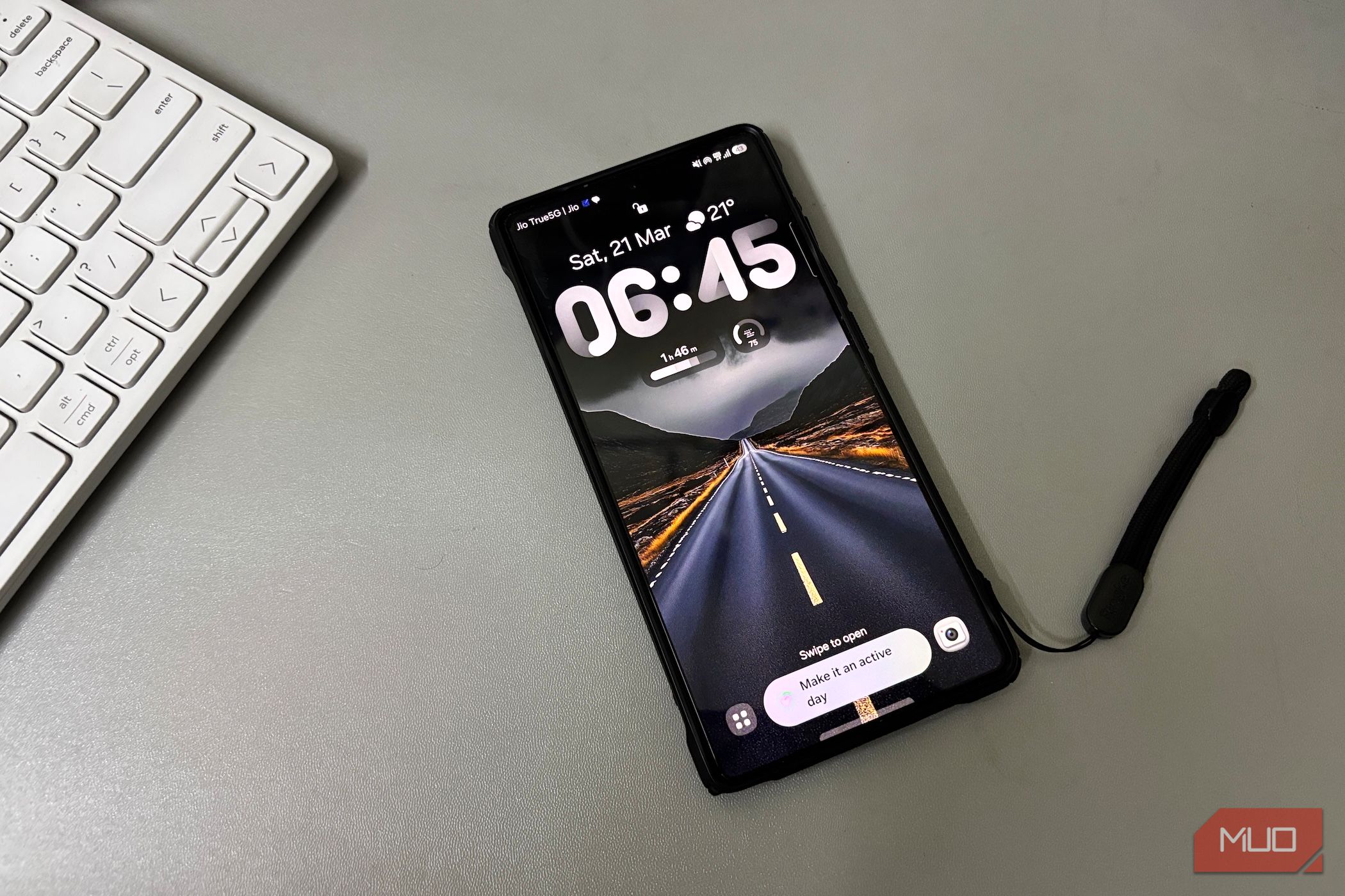 Samsung phone on desk beside keyboard-1