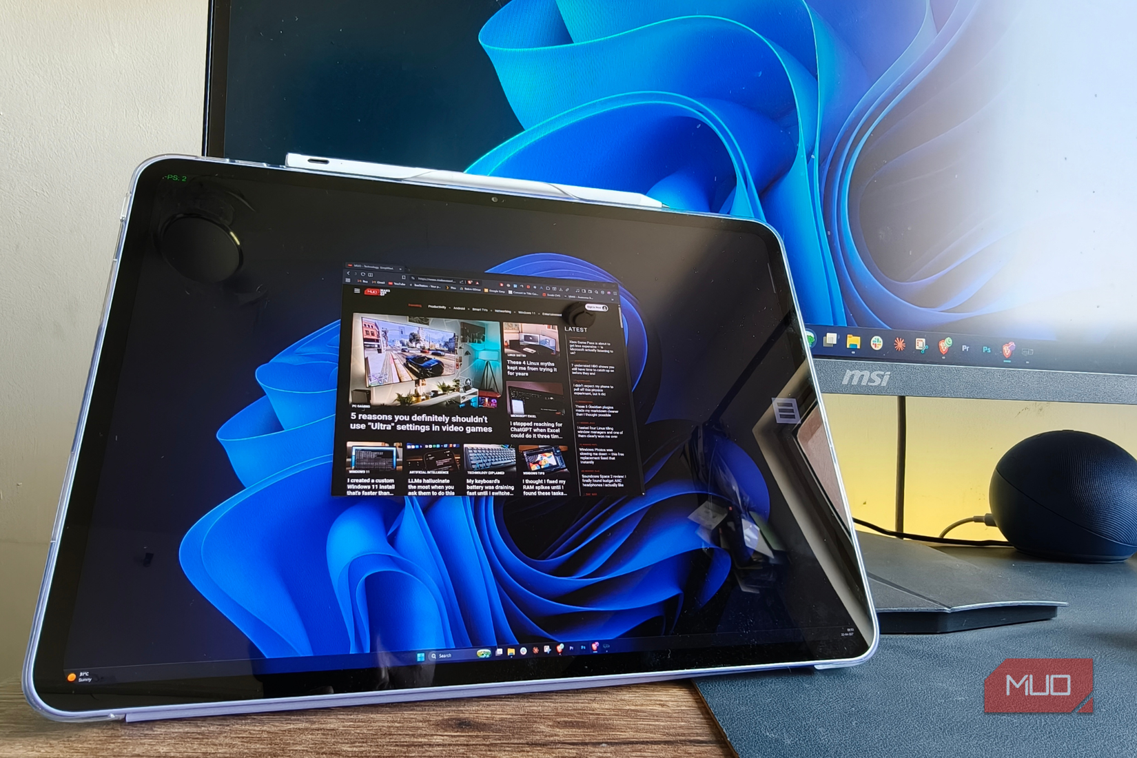 Tablet sitting besides PC on a desk