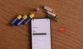 AA and AAA batteries next to an Android phone showing the battery settings