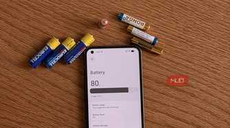 AA and AAA batteries next to an Android phone showing the battery settings