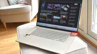 asus zenbook a16 on sofa cushion.