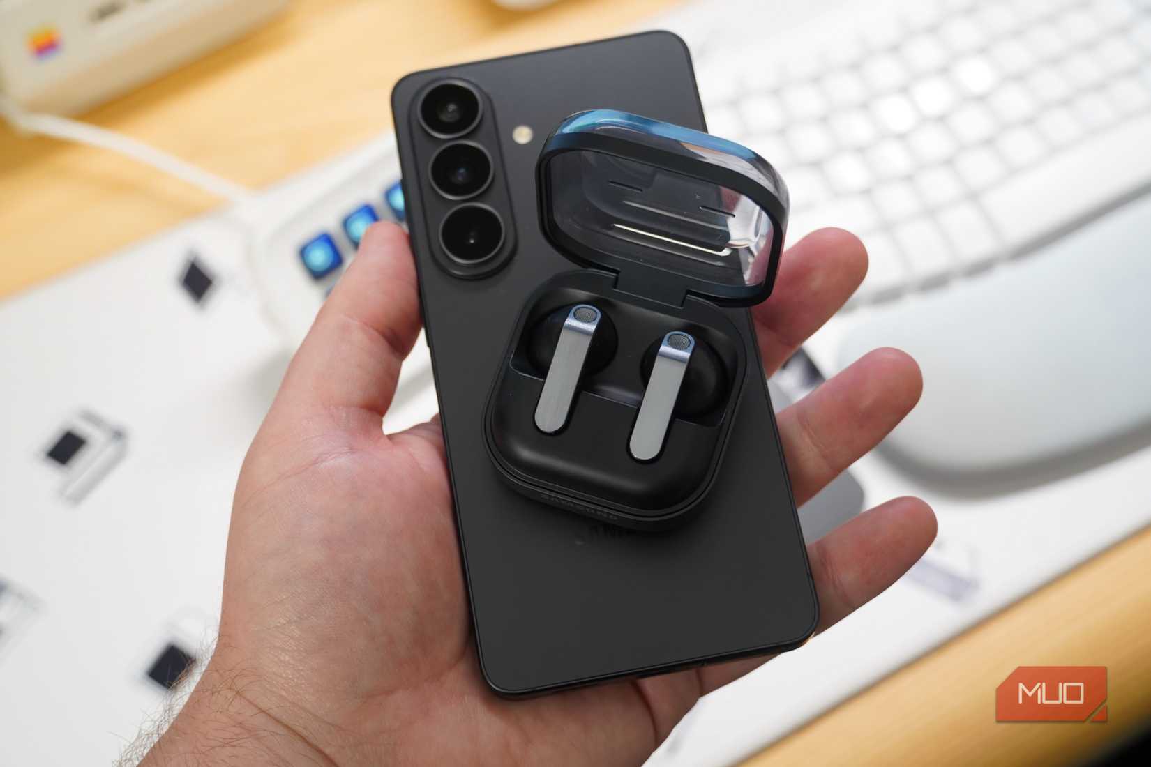Samsung earbuds and a Galaxy phone in the hand.