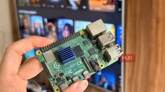Hand holding a Raspberry Pi 4 in front of a smart TV