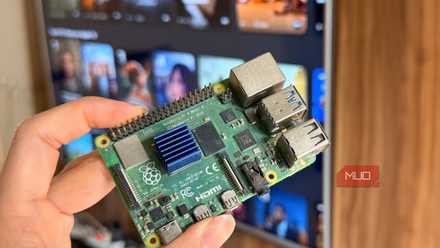 Hand holding a Raspberry Pi 4 in front of a smart TV