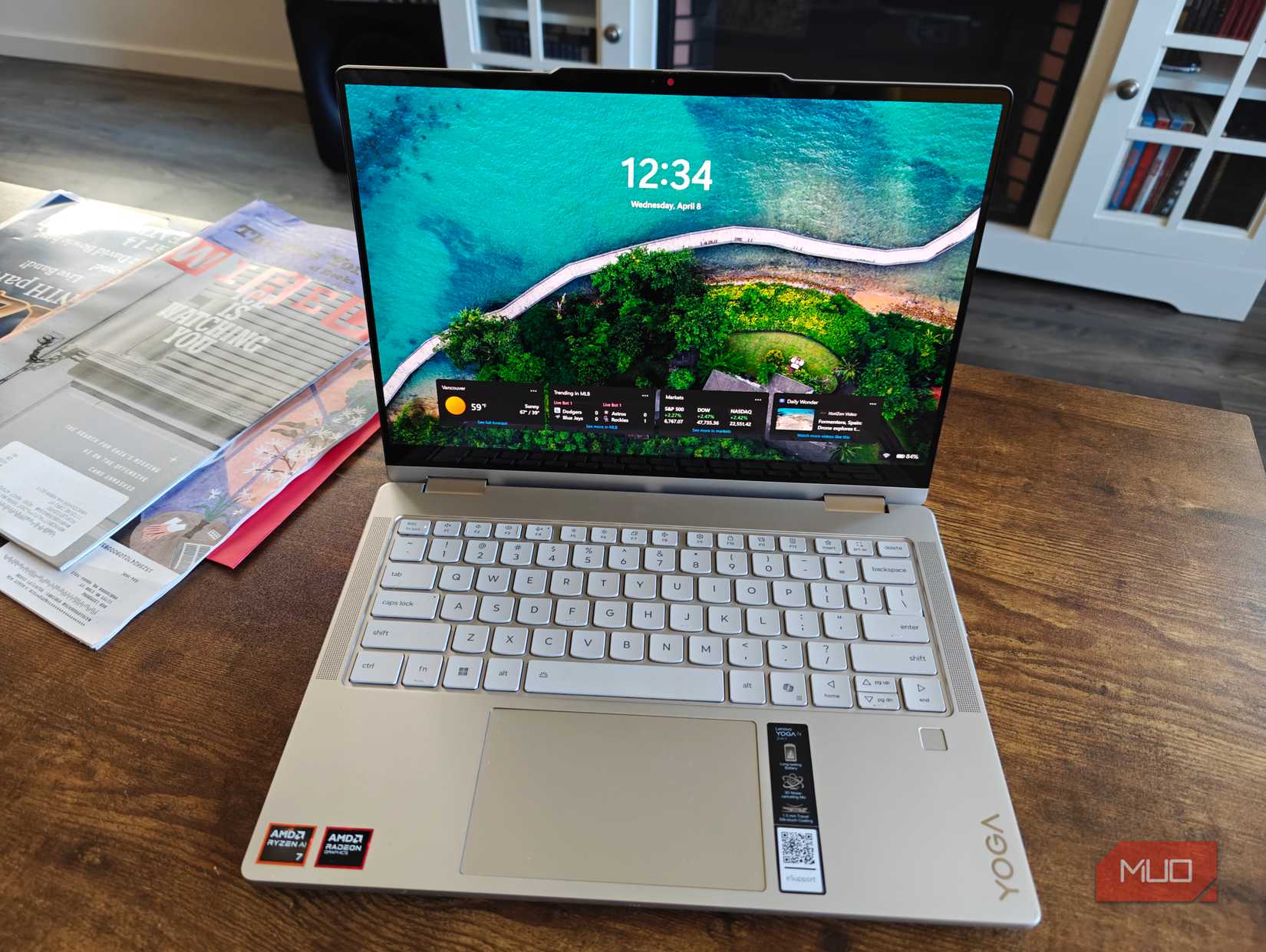 Lenovo Yoga 7a 2-in-1 di meja kopi dengan majalah