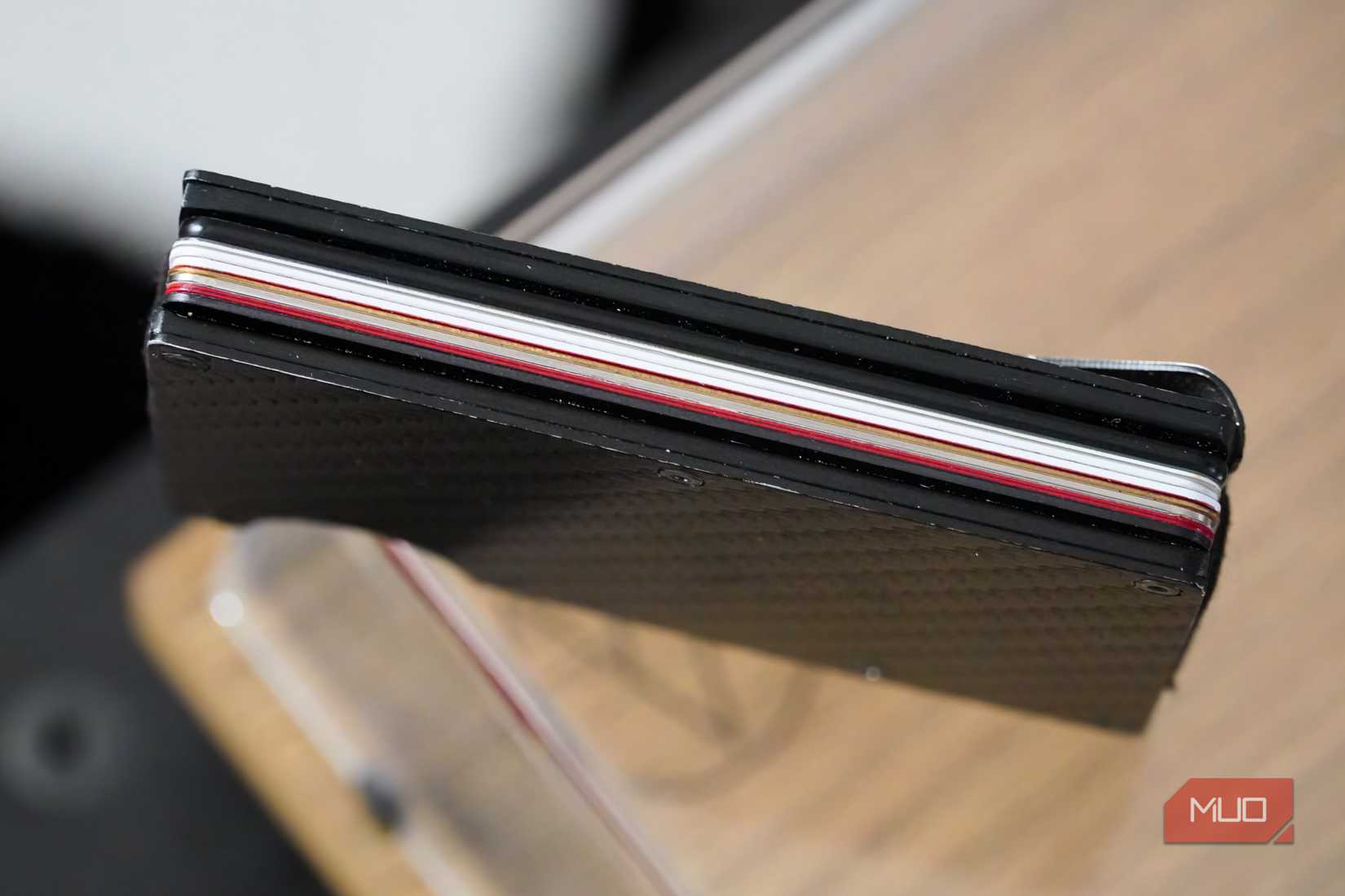 The thickness of a tracking card in a wallet.