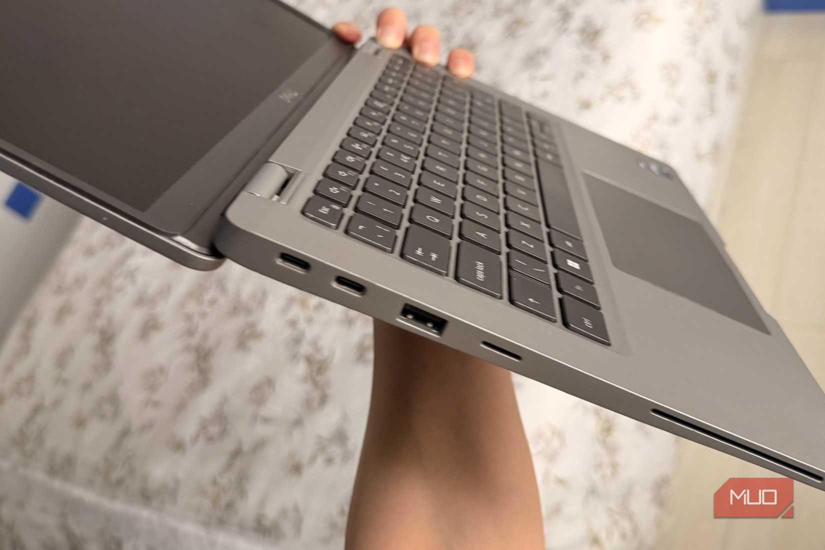 شخص يحمل جهاز Dell Latitude ويظهر على الجانب الأيسر منافذ USB-C Thunderbolt وUSB-A