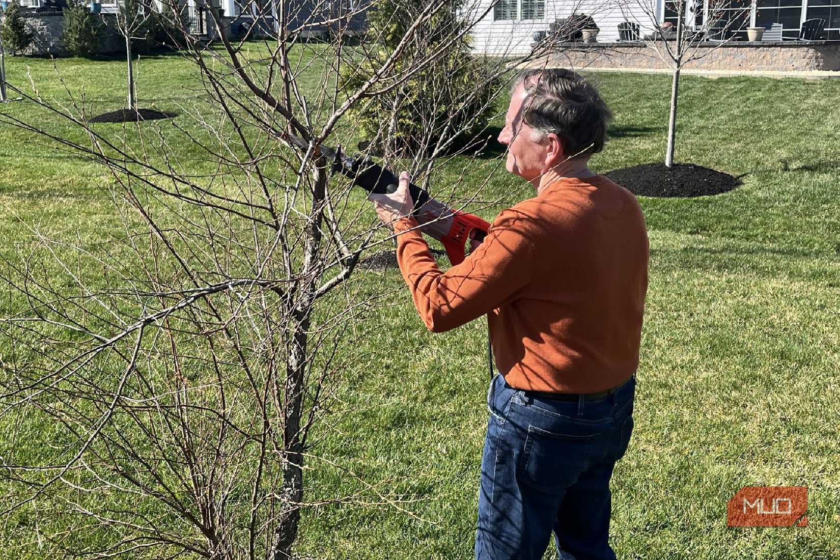 A man using a Milwaukee Sawzall Reciprocating Saw to trim branches