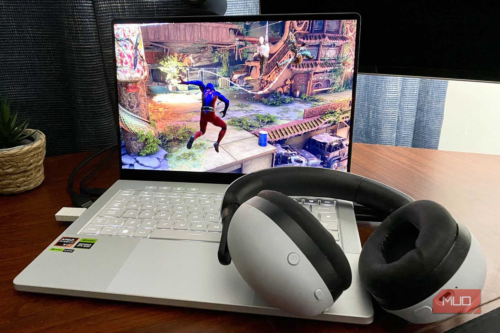 Sony Inzone H9 headset with a laptop playing Marvel's Spider-Man 2
