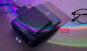 wireless charging pad and power bank with colorful light refraction on purple background next to glasses