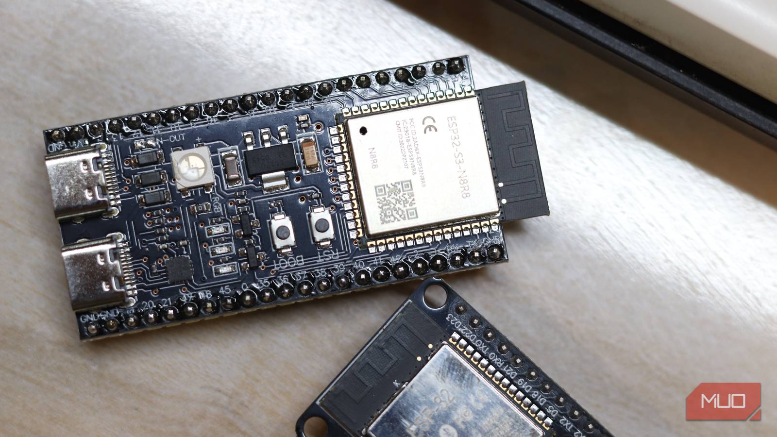 ESP32-S3 and ESP32 classic boards on a desk near a window