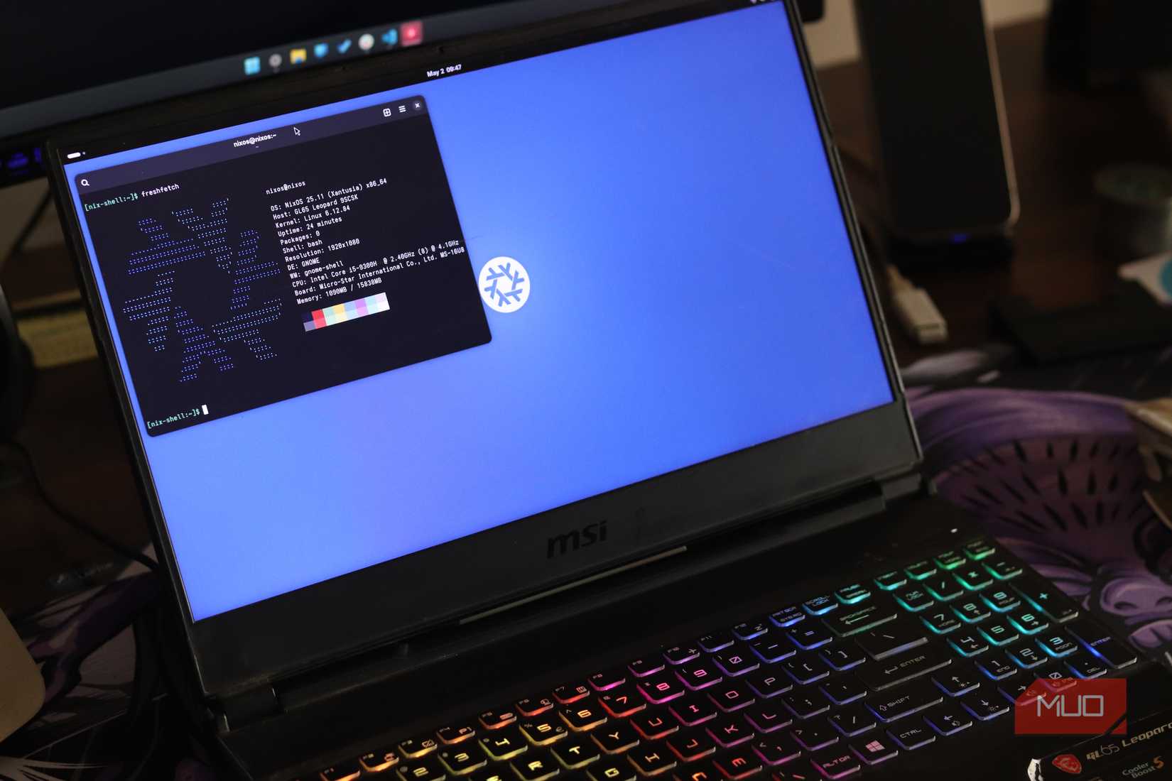 Laptop running NixOS with terminal window open.