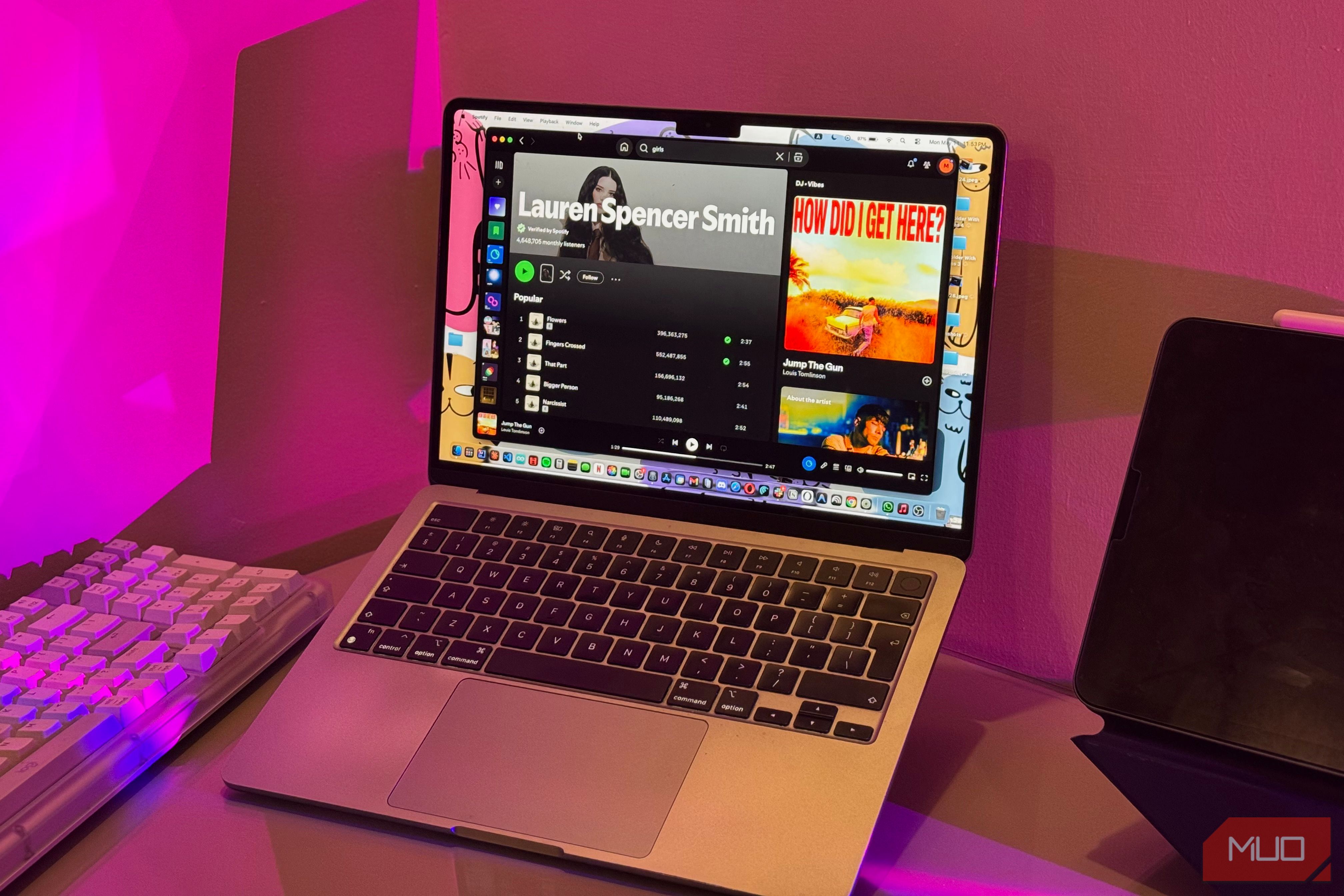 macbook laptop displaying discord interface with username lauren spencer smith on screen surrounded by pink neon lighting