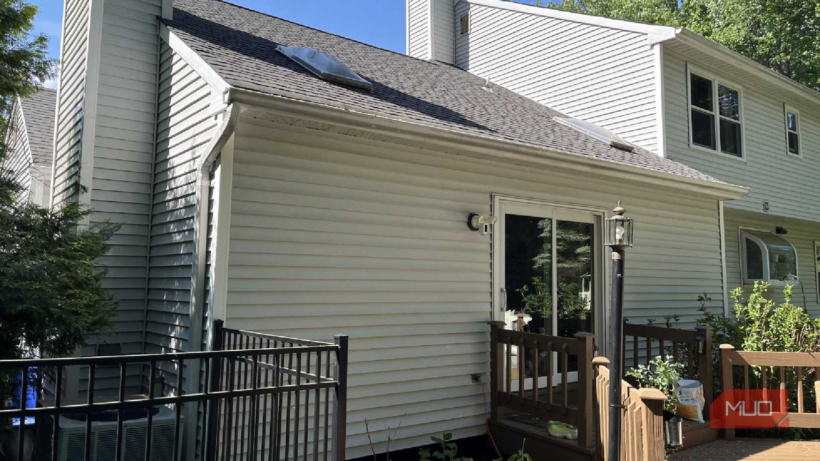 The siding of a house by a deck.