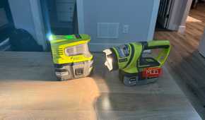 Ryobi power inverter and flashlight on desk beams across surface