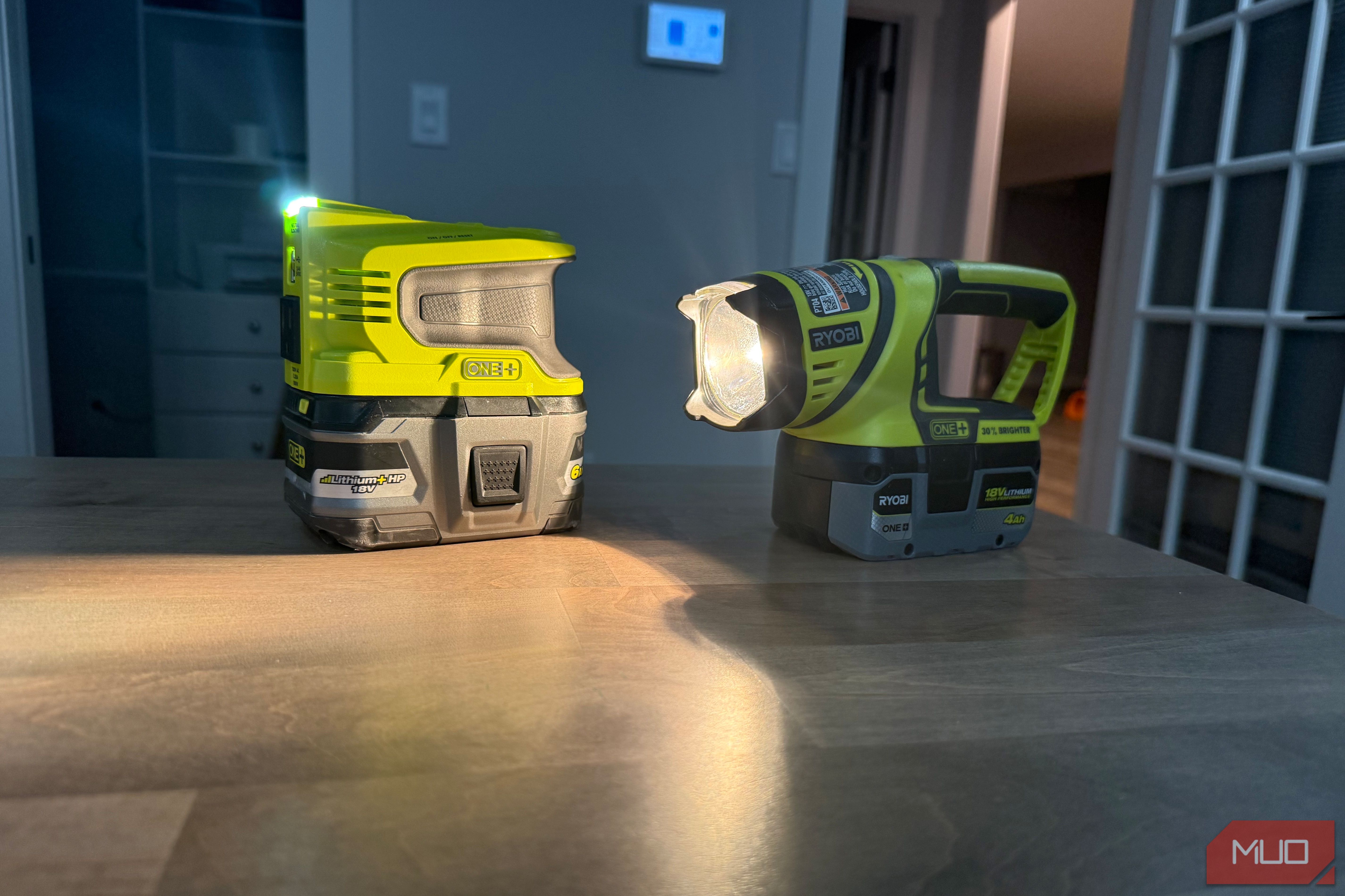 Ryobi power inverter and flashlight on desk shining onto surface