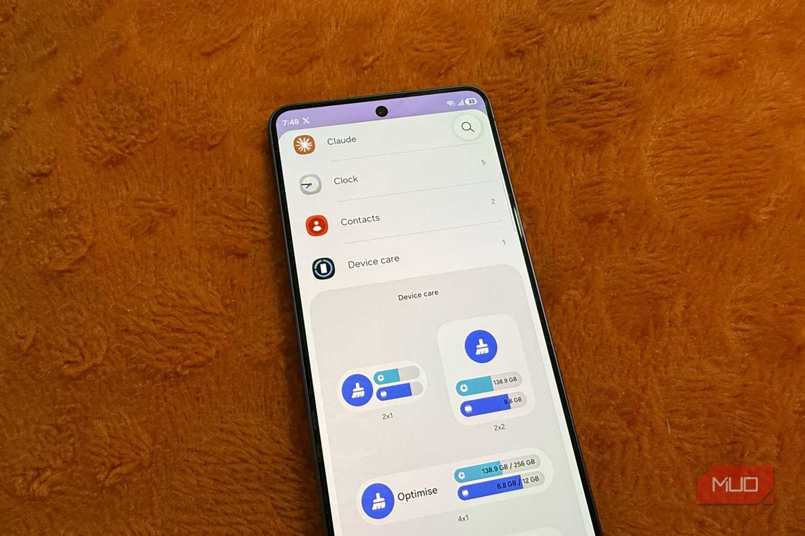 Samsung Galaxy phone on a pillow showing widgets menu