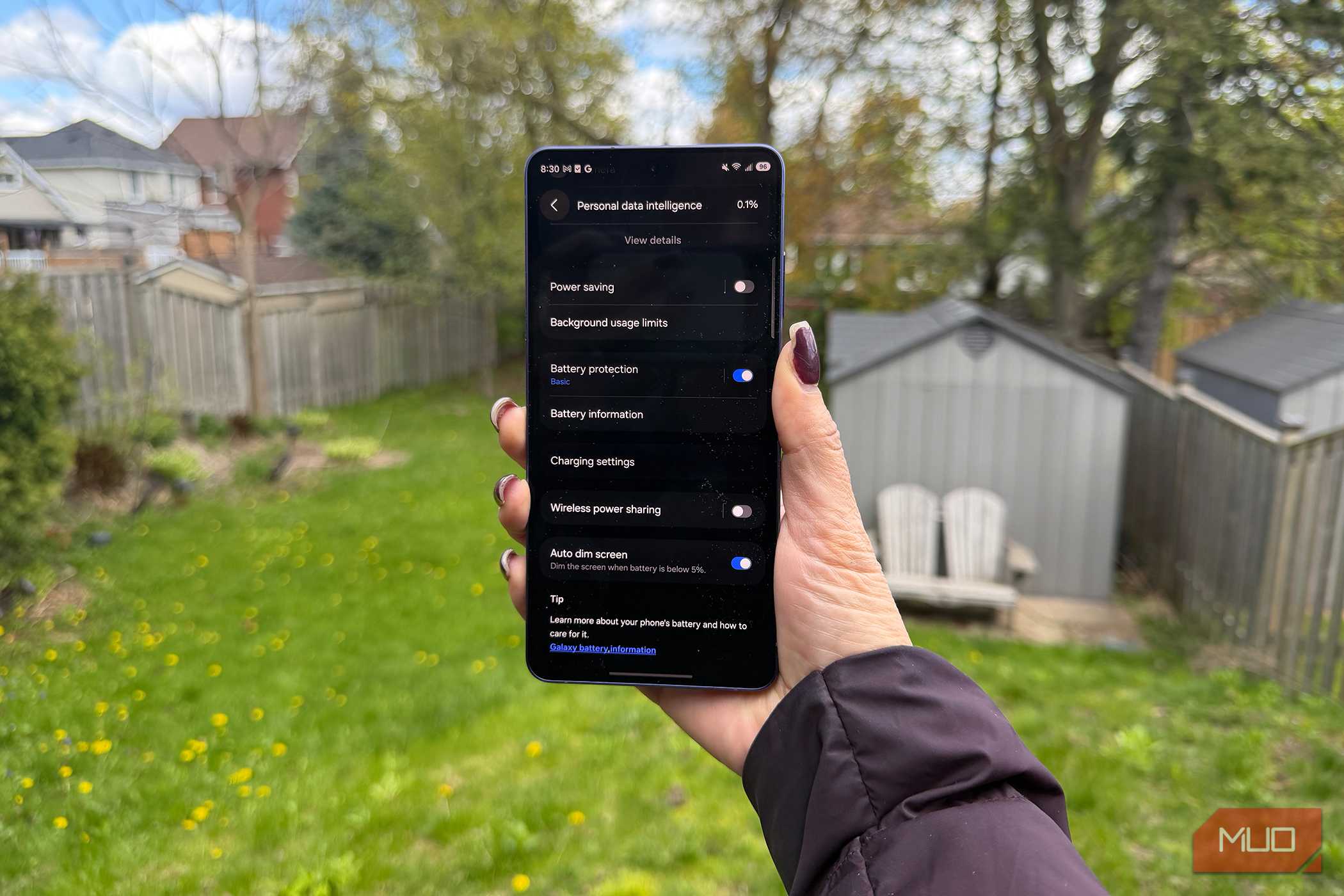 The Samsung Galaxy S26 Ultra in hand outside showing the battery menu.