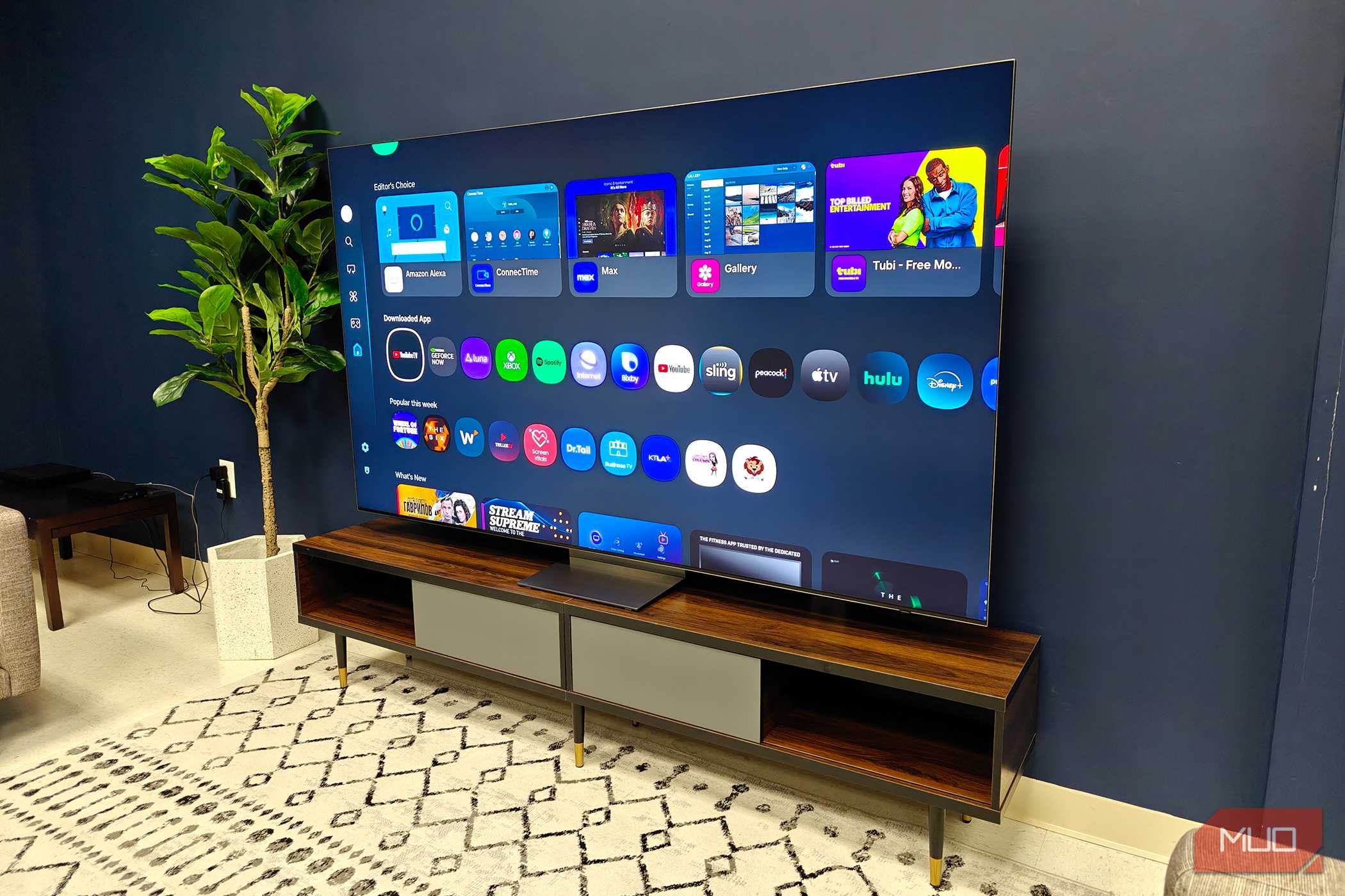 A Samsung QLED TV on a room showing a menu.